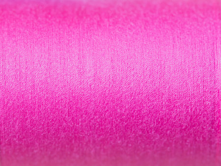 pink thread roll black background.