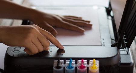Woman hand pressing copier.
