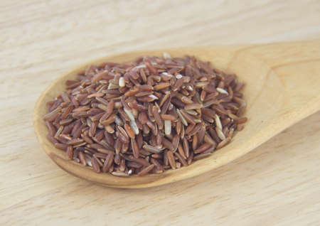 Brown rice with wooden spoon の写真素材