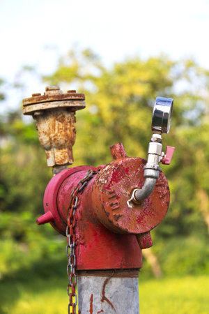 Old red fire hydrant on a sidewalk With Zero pressure meter