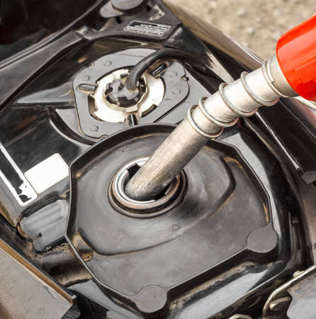 Refueling a motorcycle at a gas station の写真素材