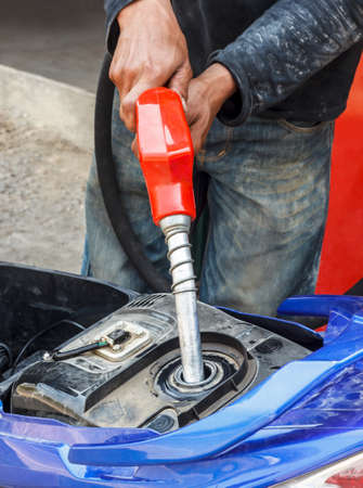 Refueling a motorcycle at a gas station の写真素材