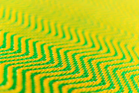 Green and yellow dirty plastic mat  zigzag  design background  textureの写真素材