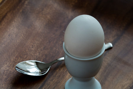 Egg in an egg cup with a spoonの写真素材