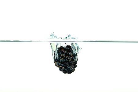 Black Blackberry falling into water with a splashの写真素材