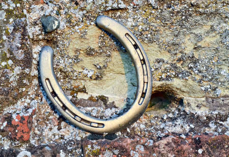 A horseshoe on a rustic wall invokes good luck and happinessの写真素材