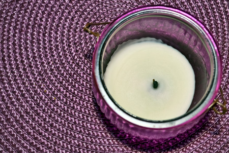 Candle in a holder placed on a vibrant backgroundの写真素材