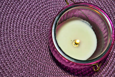 Candle in a holder placed on a vibrant backgroundの写真素材