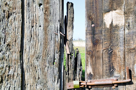 Closeup of dilapidated wooden gate in front the yardの写真素材