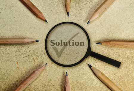 Word Solution under a magnifying glass on vintage backgroundの写真素材