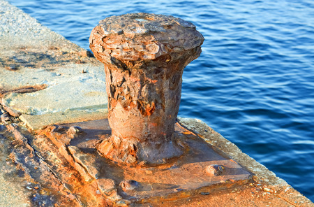 Closeup of an old anchor with rust on the pier at sunsetの写真素材