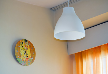 Wall clock and chandelier near the window in the living roomの写真素材