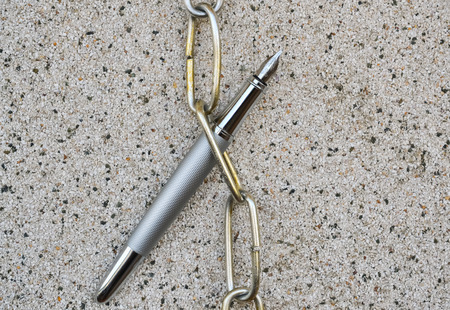 Fountain pen and chain as concept about controlling the mediaの写真素材