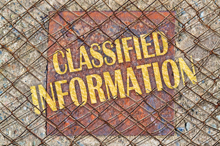 Text Classified Information written in golden color under a broken wire fenceの写真素材