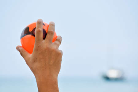Closeup of a hand holding small ball and playing a game in the waterの写真素材