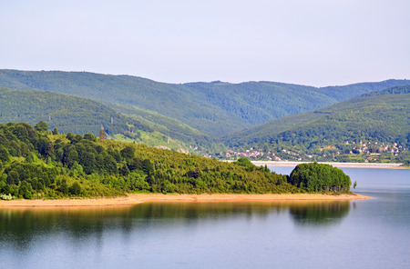 Wide view on the river flow and wooded mountainの写真素材