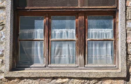Closeup of three old windows in brown wooden frames
