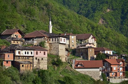 Small macedonian muslim village with mosque on the mountain slopeの写真素材