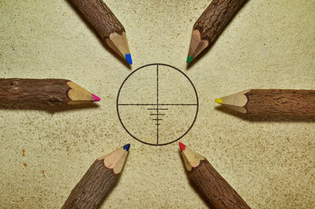 Target surrounded with pencils on grunge background