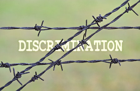 Word Discrimination written under a wire fence with barbsの写真素材