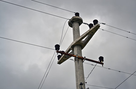 Closeup of a concrete electric pole with three phases