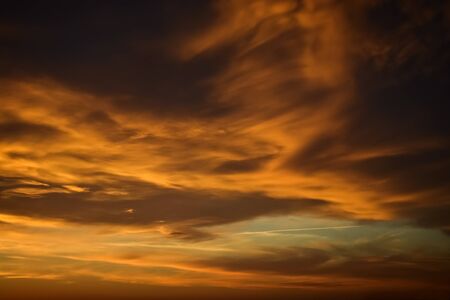 Dark moody sky with golden clouds during the sunriseの写真素材