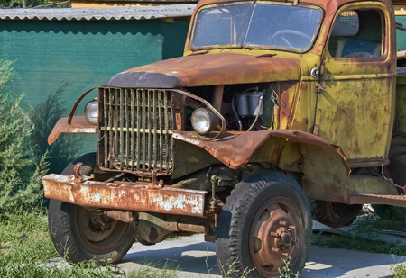 Front part of an old-fashioned  rotting truck in the yardの写真素材
