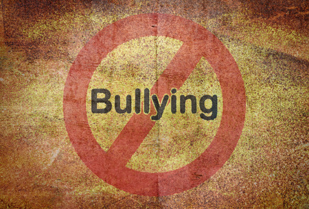 Word Bullying written over a traffic sign on grunge backgroundの写真素材