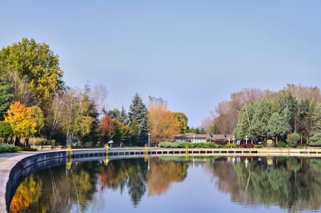 Large public swimming pool surrounded with trees in a summer dayの写真素材