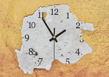 Big clock on a yellow peeling wall showing the time