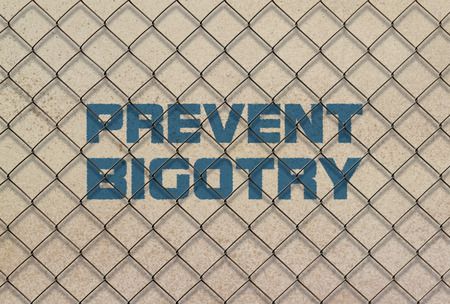 Text Prevent Bigotry written in blue under a wire meshの写真素材