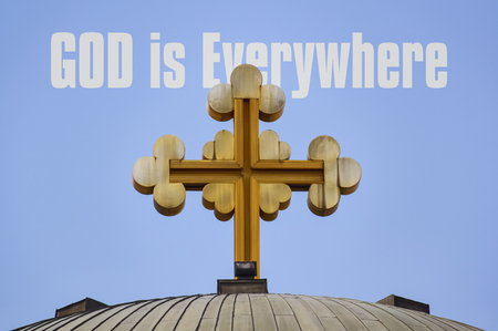 Big golden cross on the roof of a church and text God is Everywhereの写真素材