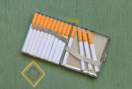 Closeup of a metal cigarette case full of cigarettesの写真素材