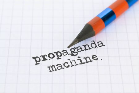 Text Propaganda Machine written on bright background and a pencilの写真素材