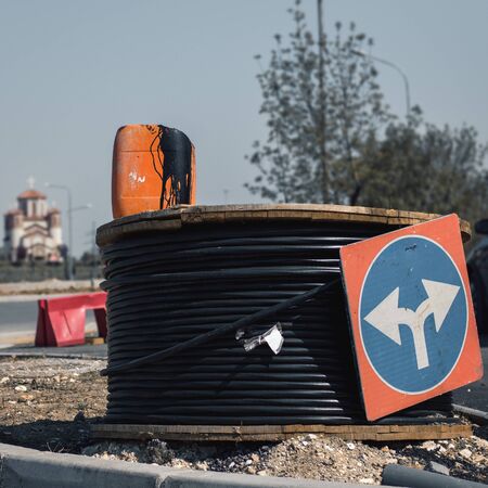 Detail of a construction site with a coil of thick electrical cable on the streetの写真素材
