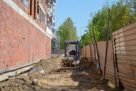 Detail of a construction site with an earthmover and new building in progressの写真素材