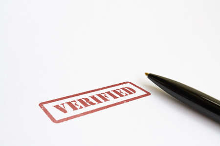 Word Verified in red color and a pen on bright backgroundの写真素材