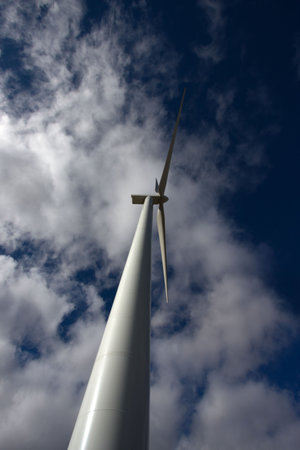 windmill under clouds sky