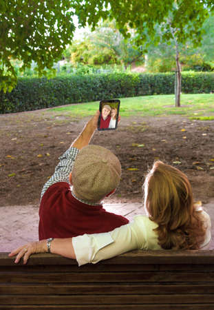 Senior man and senior woman doing a self-portraitの写真素材