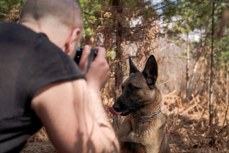 Handsome lumberjack man enjoying his time and playing with his dog in the nature.の写真素材