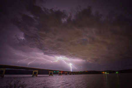 cloud to ground Lighting strikes near a bridgeの写真素材