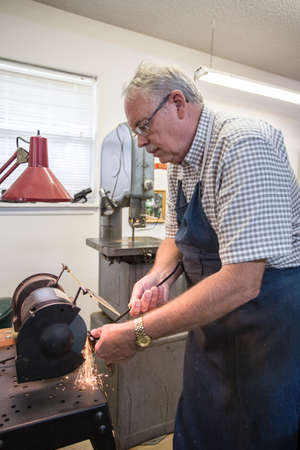 Happy Retired Man working on a large model in his workshop.の写真素材