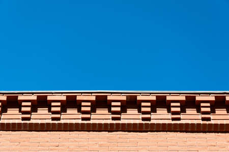 Decorative eaves from a red brick against the blue sky.の写真素材