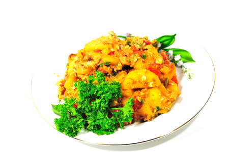 Plate with fried potatoes with tomato and egg, decorated with parsley on a white background の写真素材