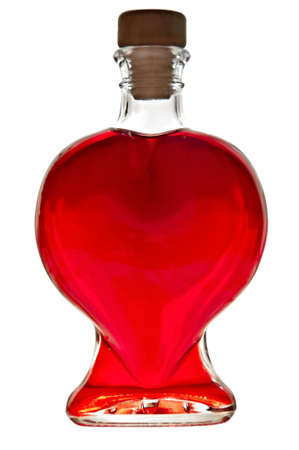 Bottle in the shape of a heart with red liquid isolated on white background の写真素材