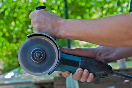 Switched on angle grinder in the man hands  Closeup 