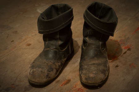 Old Boots - distressed and dirty, on a the same wooden floorの写真素材