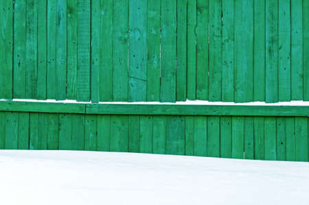 Rural Green fence and snow background.の写真素材