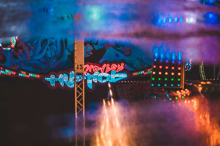 Neon Light Reflections in the water at a midnight fairの写真素材