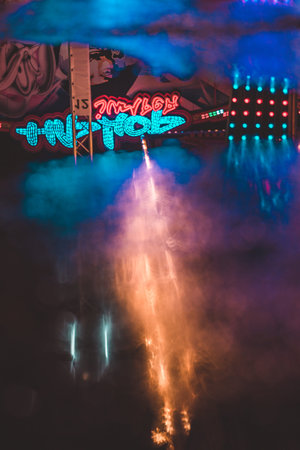 Neon Light Reflections in the water at a midnight fairの写真素材